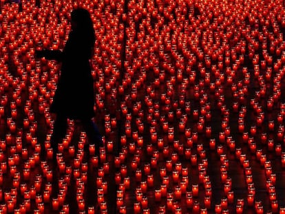 Una mujer coloca velas durante un acto solidario, en Berna (Suiza). 