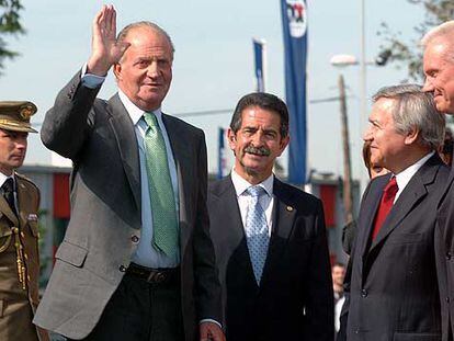 EL rey Juan Carlos saluda ayer al llegar a la fábrica de Nestlé, junto a Miguel Ángel Revilla y directivos de la empresa.