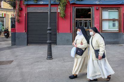 Dos monjas pasan por un restaurante cerrado en el distrito de La Latina, en Madrid, el 1 de febrero de 2021.