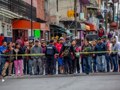 En una fotografía de septiembre de 2019, la policía municipal de Naucalpan (Estado de México) evita que vecinos se acerquen al cuerpo de un joven asesinado.