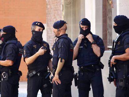 Agentes de los Mossos d'Esquadra ante el número 6 de la calle del Garraf de Cornellà donde vivía el hombre abatido a tiros este lunes.