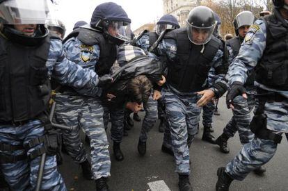 Policías antidisturbios detienen a un partidario de Timoshenko frente al tribunal.