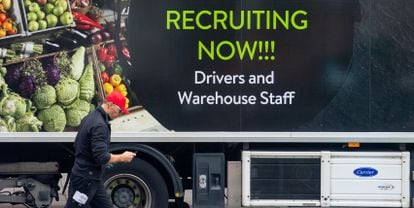 Un trabajador pasa por delante de un camión con un anuncio de contratación, el pasado miércoles en Londres.