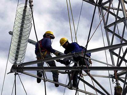 Dos operarios de Endesa trabajan en una torre de alta tensión para tratar de devolver la electricidad a Tenerife.