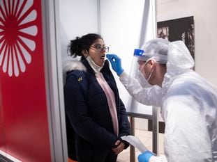 Un sanitario somete a un test de coronavirus a una pasajera, este jueves, en el aeropuerto Berlín-Brandenburg.