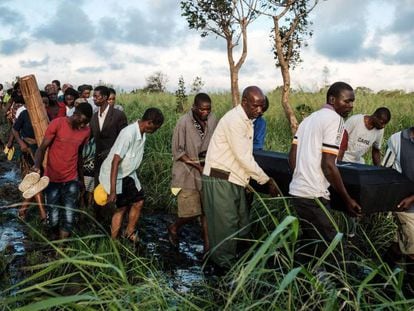 Un grupo de personas trasladan el cadáver de una persona fallecida en Mozambique.