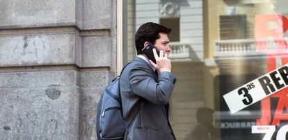 Un hombre habla por su móvil en una calle de Madrid.