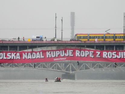Pancarta de activistas de Greenpeace en la que se podía leer "Polonia aún compra petróleo a Rusia", en un puente sobre el río Vístula, en Varsovia, este viernes, 24 de febrero.