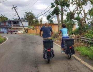 Ciclistas cargando víveres sobre sus vehículos para llegar a lugares alejados, en Puerto Rico.
