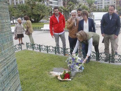 Arantza Quiroga coloca un ramo de flores ante el monolito en memoria de las víctimas en San Sebastián.