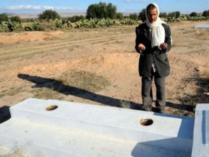 Un hombre reza ante la tumba de Mohamed Buazizi, el vendedor cuya inmolaci&oacute;n hace tres a&ntilde;os provoc&oacute; la ca&iacute;da de Ben Al&iacute;.