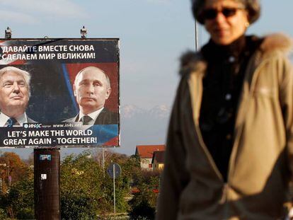 Una mujer pasa frente a un cartel que representa a Donald Trump y Vladimir Putin en Danilovgrad (Montenegro).