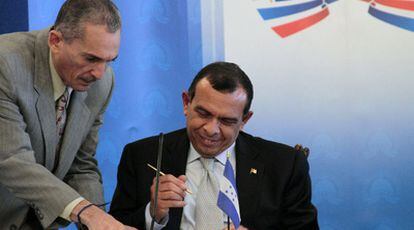 El mandatario electo de Honduras, Porfirio Lobo, firma un documento acordado con el presidente dominicano, Leonel Fernández, en Santo Domingo.
