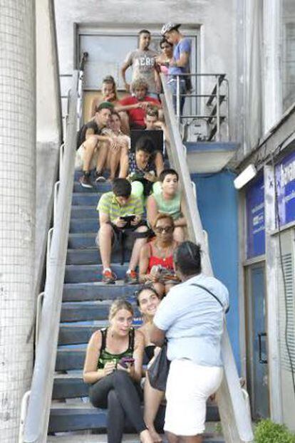 Usuarios de WiFi público en una escalera del hotel Havana Libre.