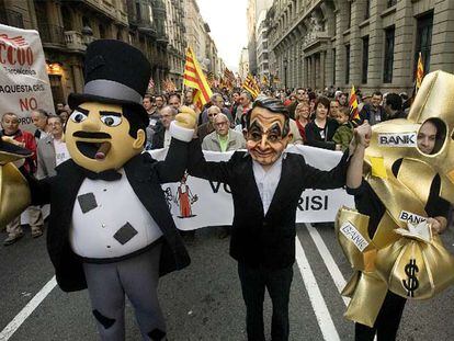 Un manifestante con una careta de Zapatero acompañado de dos muñecos símbolos del capitalismo, ayer en la Via Laietana.