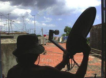 Un cubano orienta su antena de recepción en La Habana.