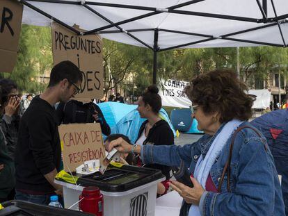 Una mujer colabora con la caja de resistencia de la acampada de plaza Universitat. 