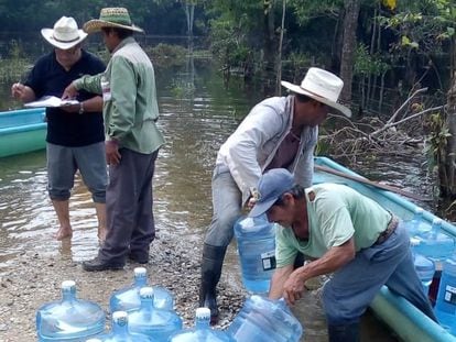 Un grupo de voluntarios carga una barca con garrafones de Segalmex, para ser distribuidos en Macuspana, Estado de Tabasco, durante las inundaciones de finales de 2020.