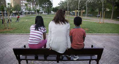Los dos menores flanquen a su madre en un parque de Sevilla.