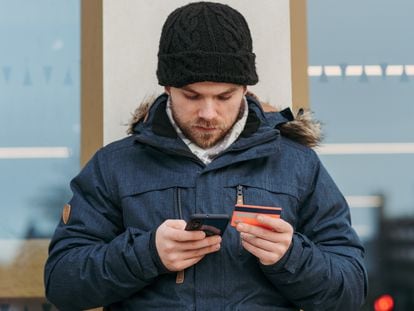 Un usuario utilizando una tarjeta bancaria en su móvil.