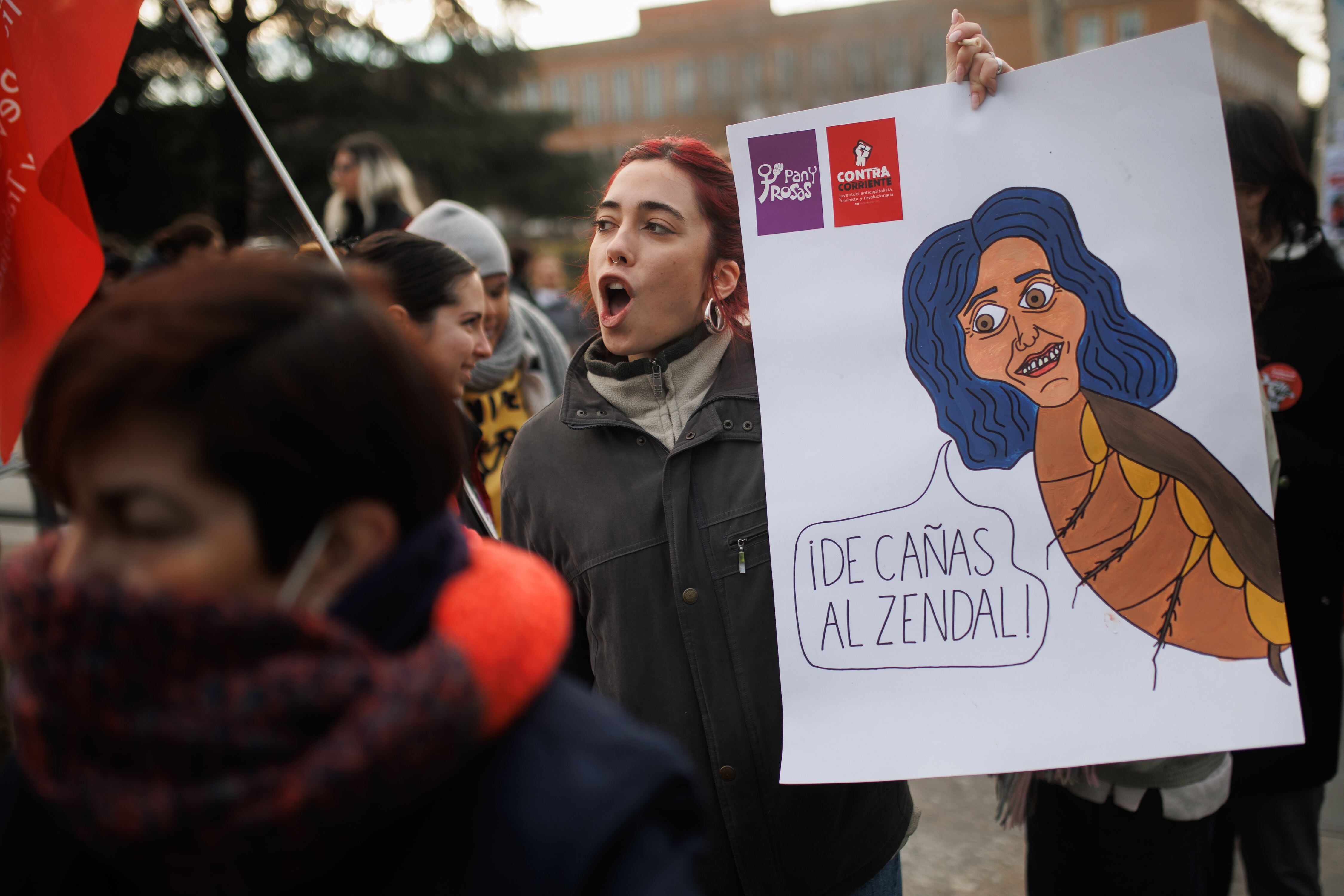 Una mujer con un cartel en el que se lee: 'De cañas al Zendal' durante la concentración en contra de la distinción de la presidenta de la Comunidad de Madrid como Alumna Ilustre de la Complutense, este martes.