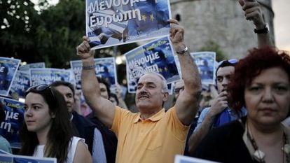 Manifestantes griegos, en una protesta este lunes en Atenas, con pancartas en las que se puede leer 'Nos quedamos en Europa'