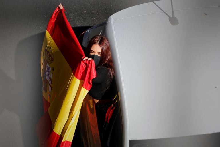  Una donna espone una bandiera durante la manifestazione motorizzata Vox contro il governo il 12 nel centro di Madrid. 