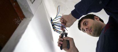 Un electricista maneja una instalaci&oacute;n el&eacute;ctrica durante la reforma de una vivienda.