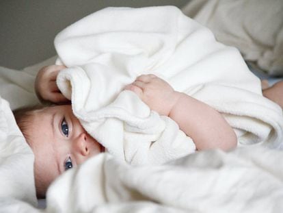 Un bebé tumbado en la cama. 