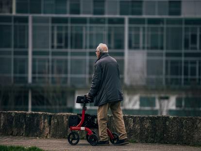 Un hombre dependiente de avanzada edad, con movilidad reducida, realiza un paseo como parte  de su trabajo de mantenimiento, este lunes.