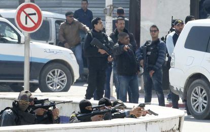 Polic&iacute;as tunecinos permanecen atrincherados tras un muro en el exterior del Parlamento.
