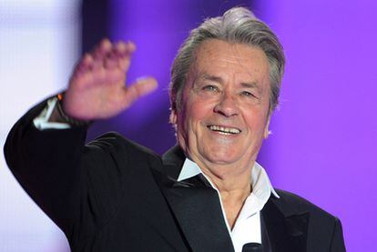 Alain Delon saluda a la audencia, en la fase previa del certamen de belleza Miss Francia 2011, celebrada en Caen, el 4 de diciembre de 2010.
