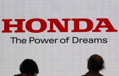 Dos personas miran el eslogan de la marca de coches nipona Honda.