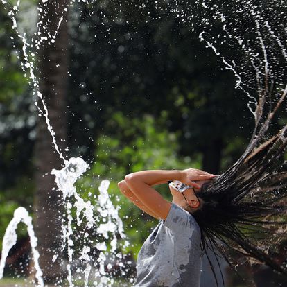 GRAF7928. CÓRDOBA, 01/08/2020.-Una chica se refresca en una de las fuentes de la ciudad, para aliviar las altas temperaturas, hoy sábado Córdoba continúa en aviso naranja por altas temperaturas. EFE/Salas