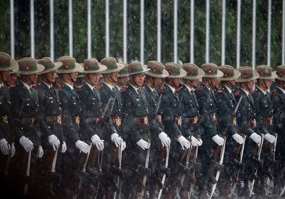 Militares nepalíes esperan bajo la lluvia para recibir al presidente de Sri Lanka, Maithripala Sirisena, en Katmandú (Nepal).