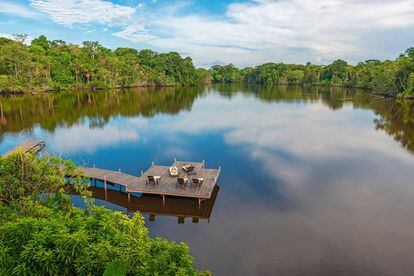 Tuistas disfrutan de un baño de sol en unas hamacas de un 'resort' a las orillas del río Amazonas, en Ecuador.
