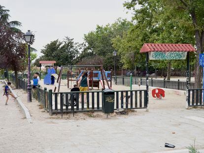 Una familia juega en la área infantil del parque de la Cornisa, Madrid.