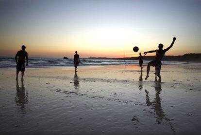 Unos jóvenes juegan al fútbol en una playa de Conil.