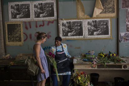 Faldela Dixon habla con una cliente en su floristería en Ciudad del Cabo el 1 de febrero de 2018. Dixon dice que la gente ya no compra tantas flores debido a la sequía, ya que no quieren derrochar agua para regarlas.