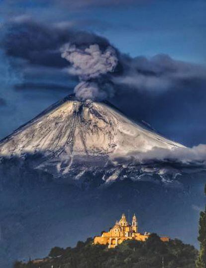 El santuario de Nuestra Señora de los Remedios y, al fondo, el volcán Popocatépetl (México), escenario de la novela Bajo el volcán. 