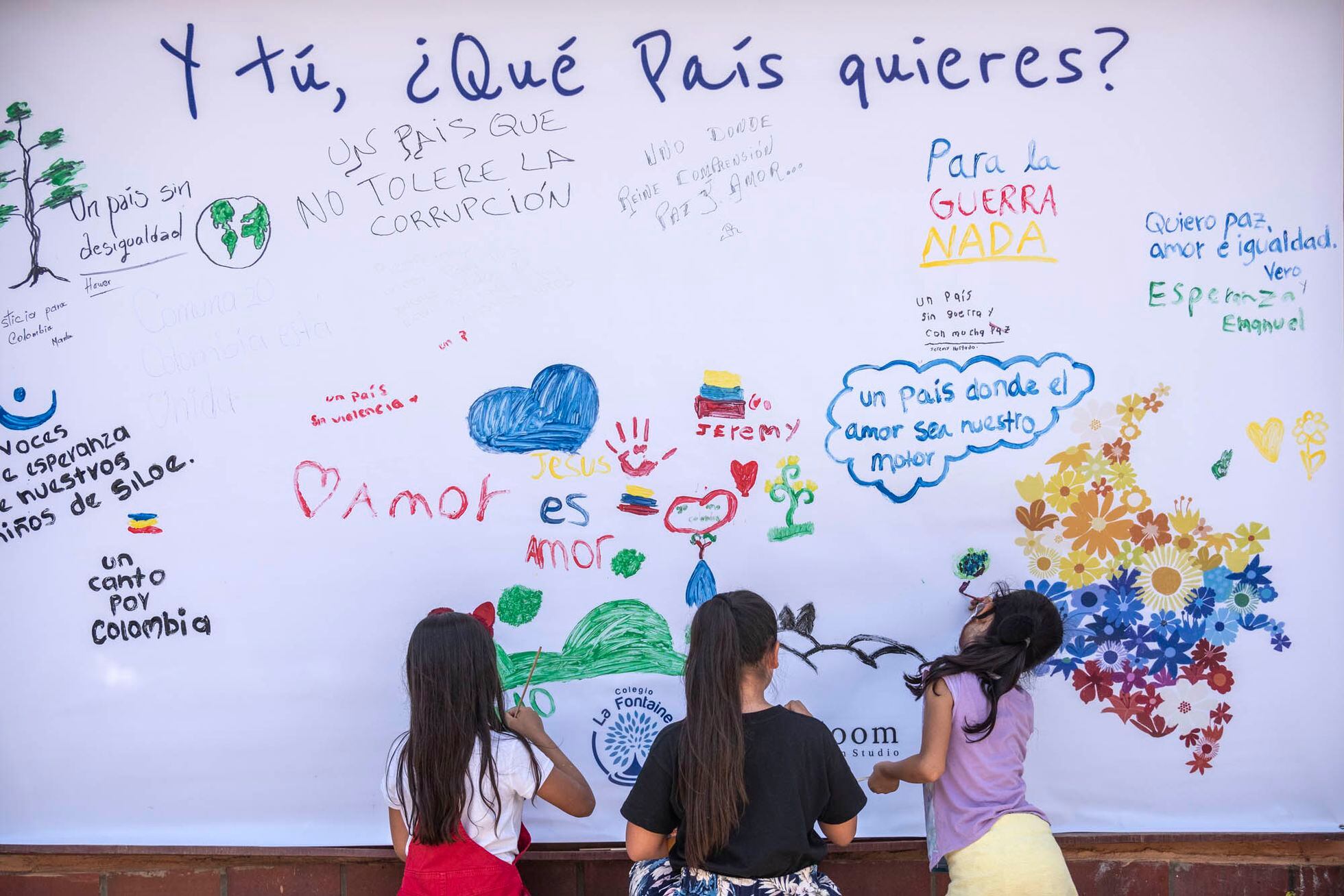 Niños de un colegio del barrio Siloé (Cali) escriben consignas en un muro.