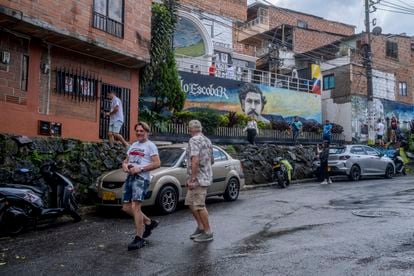 Several tourists walk the streets of the Pablo Escobar neighborhood.