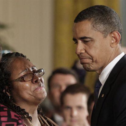 Obama, ayer junto a la hermana de una víctima de un crimen racial.