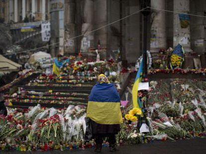 Una mujer con una bandera de Ucrania en un memorial en la Plaza de la Independencia de Kiev.