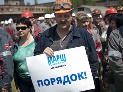 Un trabajador de Ajm&eacute;tov con un cartel que reza &ldquo;Marcha. Disciplina&rdquo;, en Mari&uacute;pol.