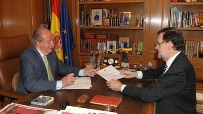 El rey Juan Carlos I entrega a Rajoy el documento de abdicación.