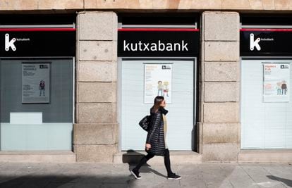 Una mujer camina por delante de una sucursal de Kutxabank, en Salamanca.