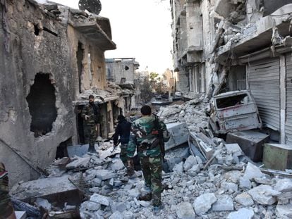 Soldados del Ejército sirio caminan en medio de una gran destrucción en el barrio de Bustan al-Basha, en Alepo, en el transcurso de su asalto para retomar la ciudad del control de los combatientes rebeldes.