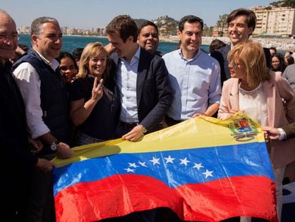 El presidente del PP, Pablo Casado, posa en Málaga, junto a representantes del PP andaluz, con una bandera venezolana. 