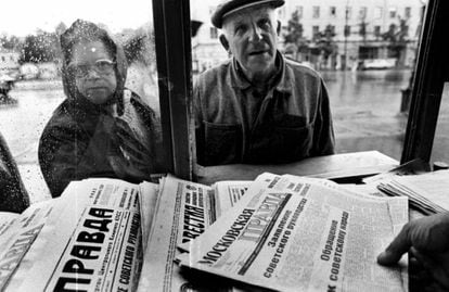 Dos ciudadanos rusos se acercan a un quiosco para comprar un periódico que titula "Anuncio al pueblo soviético" por parte de los líderes del golpe, el 20 de agosto de 1991 en Moscú.